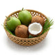 Fresh Indian coconuts in a bamboo basket, green young and mature brown husked, one cracked open showing white flesh